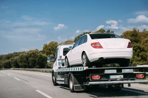 Insurance Towing 2 car being transported on the top of flatbed tow truck